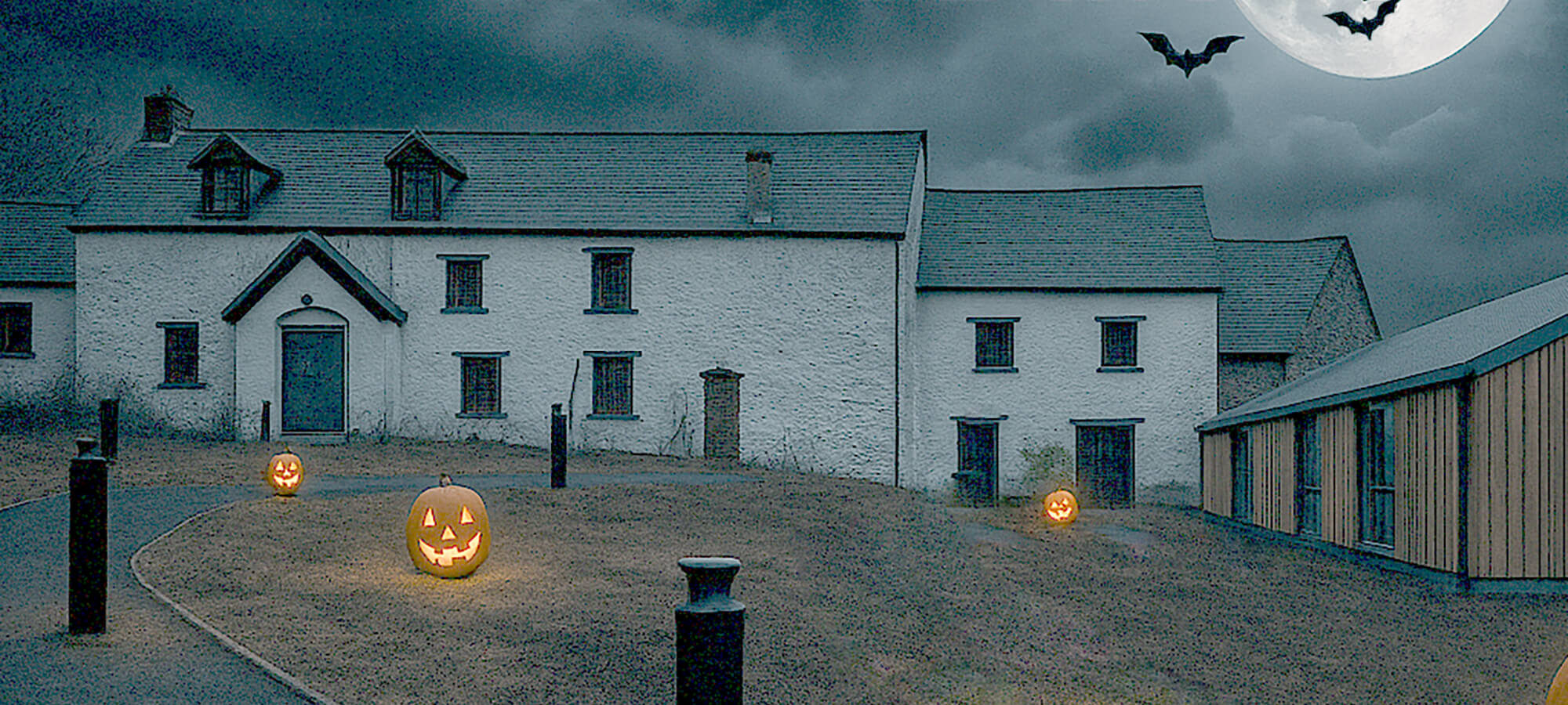 Farm building looking spooky with pumpkins and bats