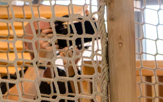 Young girl enjoying the slide in the indoor adventure play at Greenmeadow Community Farm